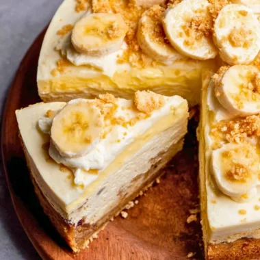 Slice of banana pudding cheesecake with vanilla wafers and banana slices on top