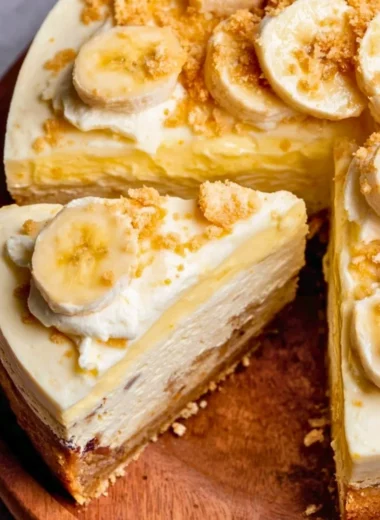 Slice of banana pudding cheesecake with vanilla wafers and banana slices on top