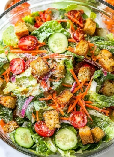 Classic house salad with fresh vegetables and dressing served in a bowl.