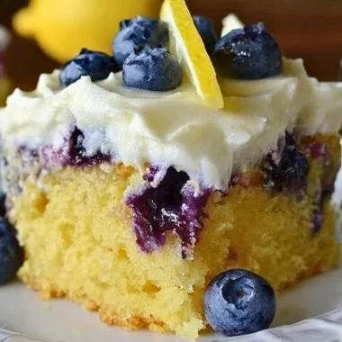 Delicious Lemon Blueberry Poke Cake topped with fresh blueberries.