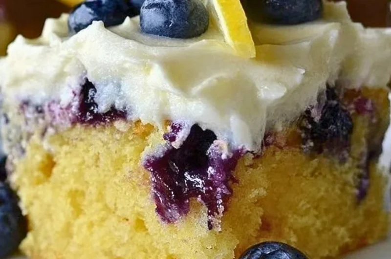Delicious Lemon Blueberry Poke Cake topped with fresh blueberries.
