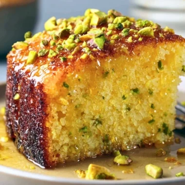 Cozy lemon pistachio cake topped with fresh lemon zest and crushed pistachios