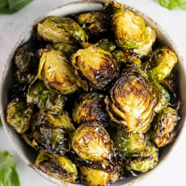 Crispy oven roasted brussel sprouts with balsamic glaze on a serving plate