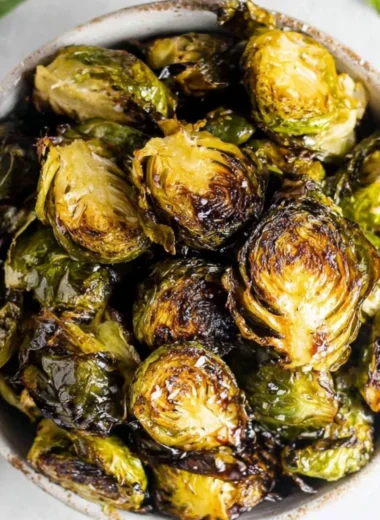 Crispy oven roasted brussel sprouts with balsamic glaze on a serving plate