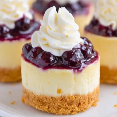 Healthy mini lemon blueberry cheesecakes topped with fresh blueberries