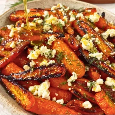 Honey garlic roasted carrots topped with feta cheese, a flavorful side dish.