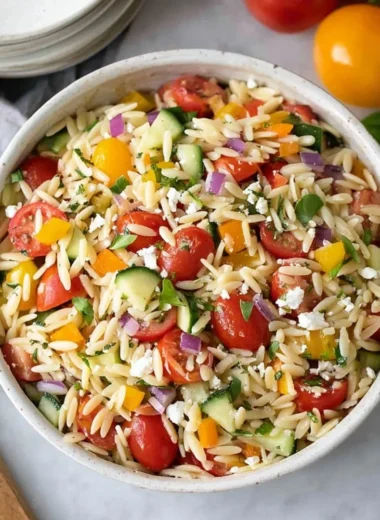 Colorful bowl of Orzo Salad with vegetables and herbs