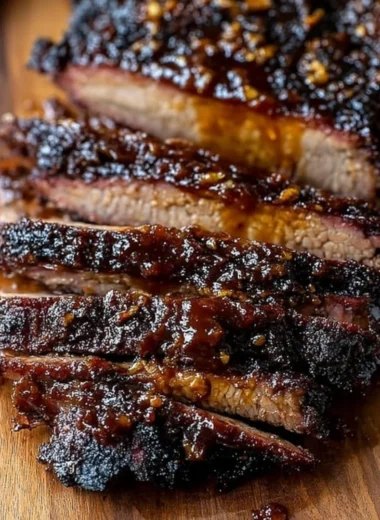 Delicious Oven-Baked BBQ Beef Brisket served on a plate with BBQ sauce