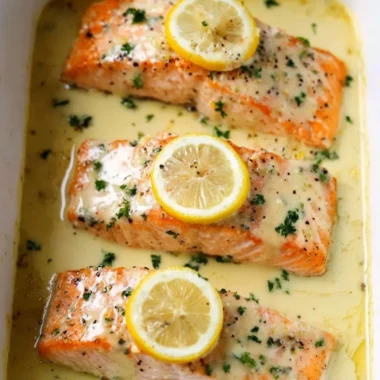 Delicious salmon fillet topped with creamy lemon sauce on a plate