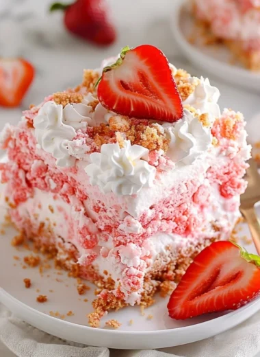 Delicious strawberry crunch poke cake topped with crunchy strawberry crumbs.