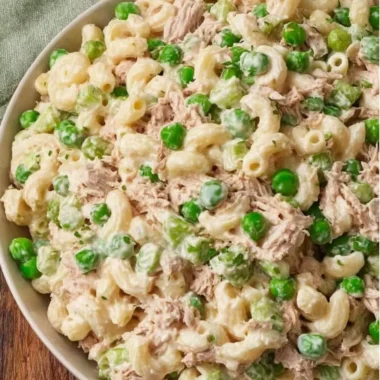 Bowl of tuna pasta salad with fresh vegetables and dressing