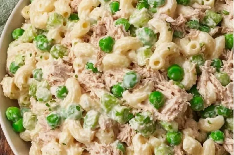 Bowl of tuna pasta salad with fresh vegetables and dressing