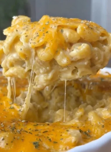 Bowl of spicy Buffalo Mac and Cheese topped with cheese and herbs