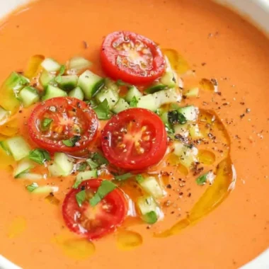 Bowl of easy gazpacho garnished with fresh herbs and vegetables