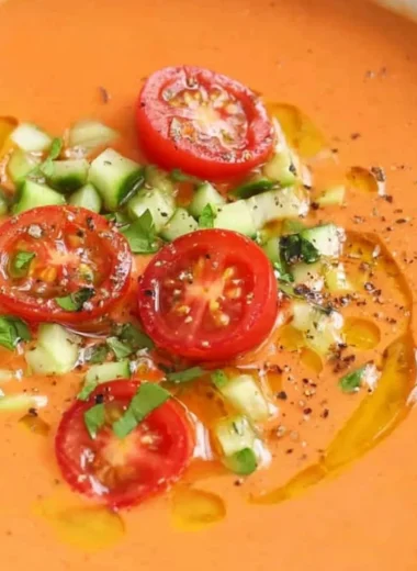 Bowl of easy gazpacho garnished with fresh herbs and vegetables
