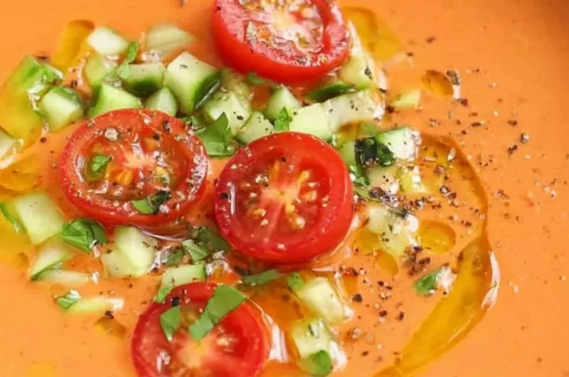 Bowl of easy gazpacho garnished with fresh herbs and vegetables