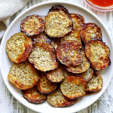 Bowl of homemade crispy eggplant chips served with dipping sauce