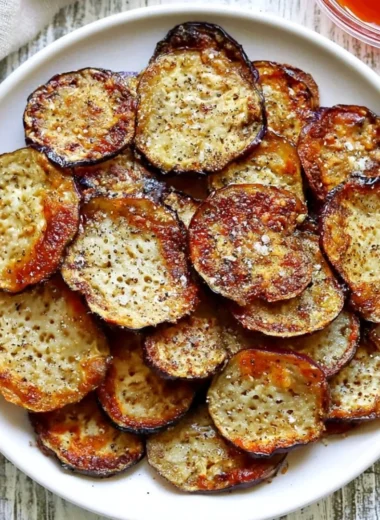 Bowl of homemade crispy eggplant chips served with dipping sauce