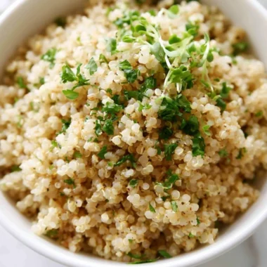 Bowl of Herb and Garlic Quinoa garnished with fresh herbs and garlic cloves.