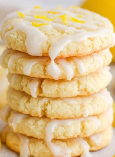 Lemon sugar cookies on a baking tray with a zesty lemon slice
