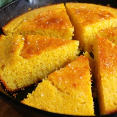 Slice of homemade old-fashioned cornbread served on a rustic wooden table