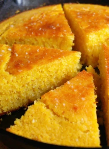 Slice of homemade old-fashioned cornbread served on a rustic wooden table
