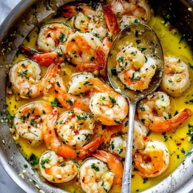 Delicious shrimp scampi with garlic, parsley, and lemon served over pasta.