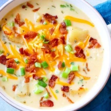 Delicious slow cooker potato soup in a bowl topped with herbs
