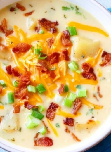 Delicious slow cooker potato soup in a bowl topped with herbs