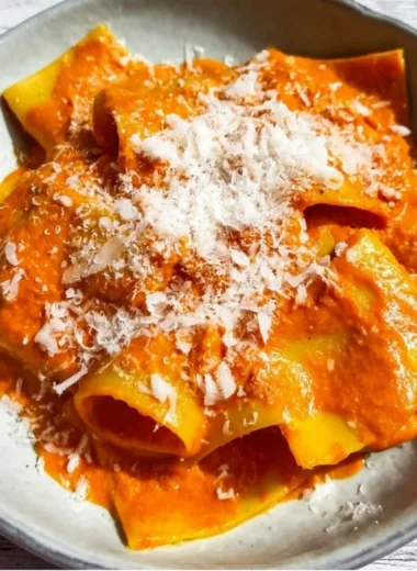 Creamy vodka pasta dish garnished with herbs and Parmesan cheese