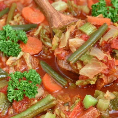 A warm bowl of cabbage soup for weight loss with fresh ingredients.