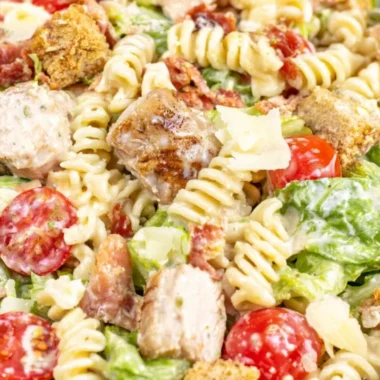 Bowl of Chicken Caesar Pasta Salad topped with croutons and Parmesan cheese