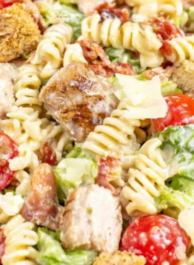 Bowl of Chicken Caesar Pasta Salad topped with croutons and Parmesan cheese
