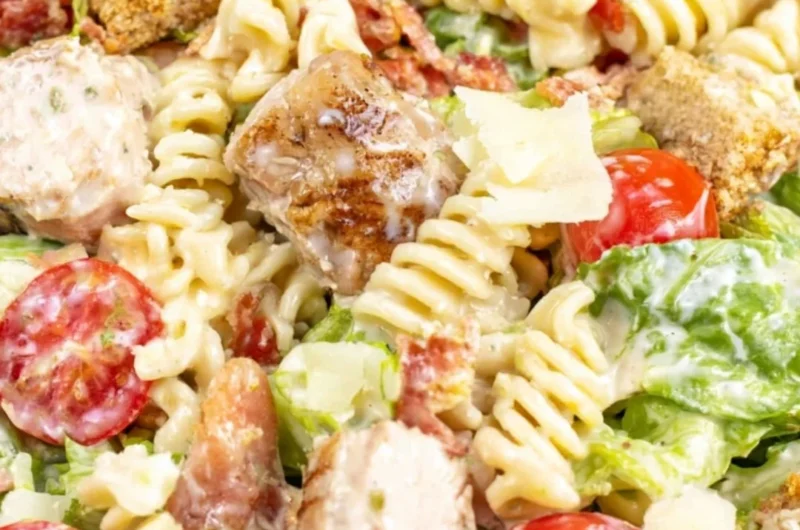 Bowl of Chicken Caesar Pasta Salad topped with croutons and Parmesan cheese