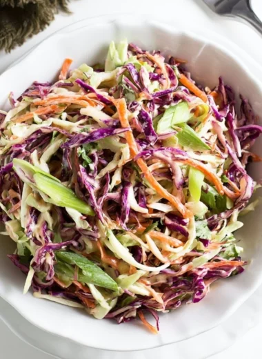 Cozy coleslaw served alongside pulled pork sandwiches on a wooden table
