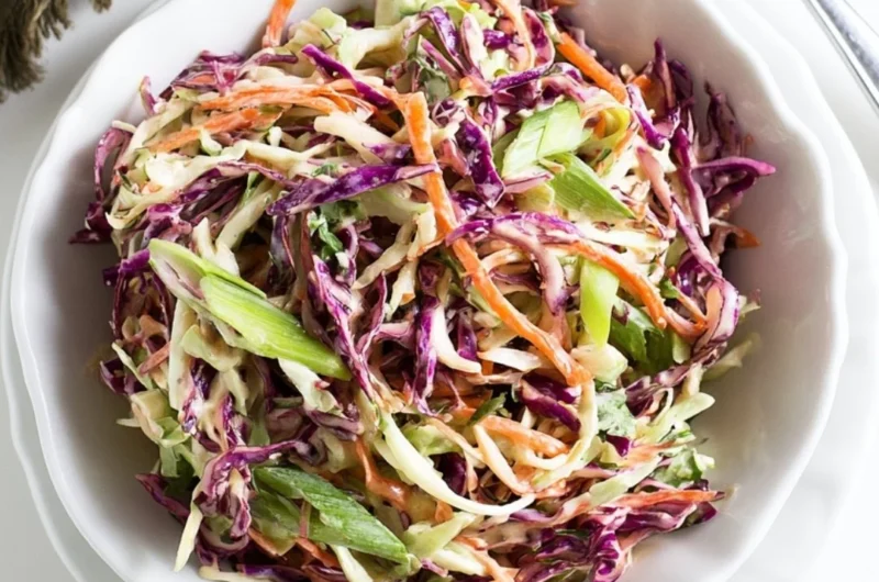 Cozy coleslaw served alongside pulled pork sandwiches on a wooden table