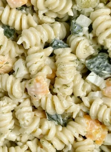 Delicious Dill Pickle Pasta Salad in a bowl, garnished with fresh herbs.