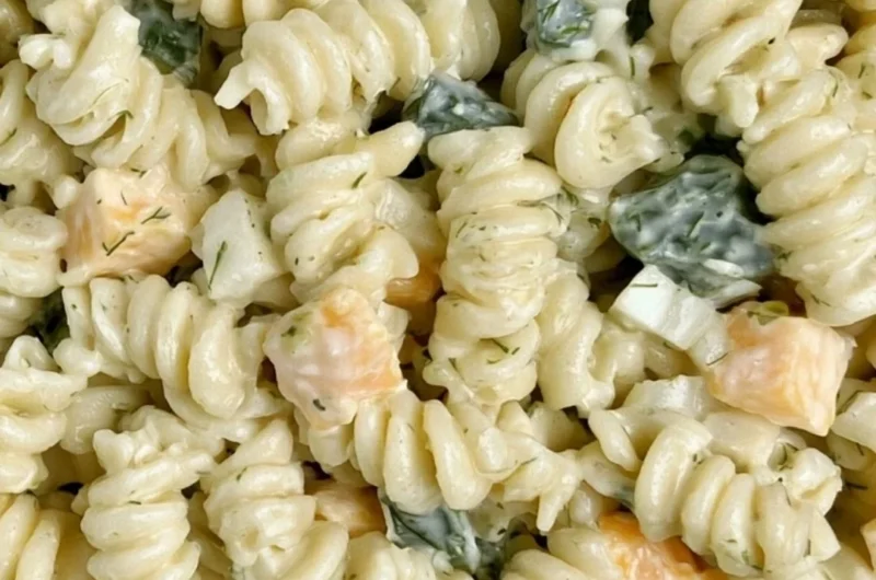Delicious Dill Pickle Pasta Salad in a bowl, garnished with fresh herbs.