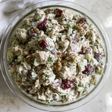 Healthy chicken salad without mayo served in a bowl, garnished with herbs.