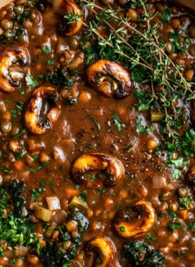 A bowl of Vegan Lentil Mushroom Stew garnished with fresh herbs